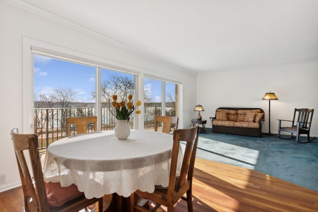 dining area featuring hardwood / wood-style flooring and ornamental molding