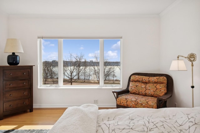 bedroom featuring light wood-type flooring, ornamental molding, and multiple windows