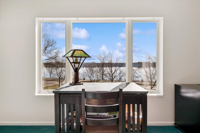 dining area featuring dark colored carpet and plenty of natural light