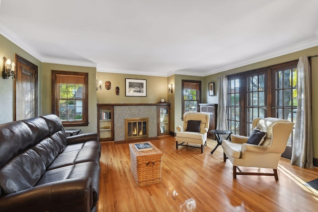 living room featuring wood-type flooring, a tile fireplace, and plenty of natural light