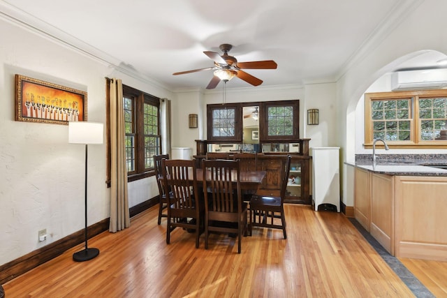 dining area featuring crown molding, a wall mounted AC, ceiling fan, and light hardwood / wood-style flooring