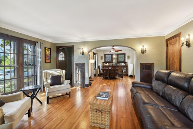 living room with crown molding and light hardwood / wood-style floors