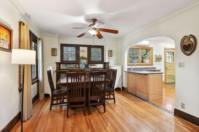 dining space with crown molding, a wall unit AC, light hardwood / wood-style floors, and ceiling fan