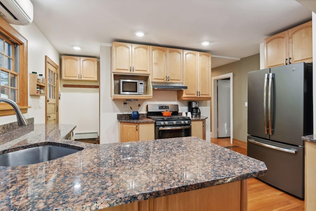 kitchen featuring sink, baseboard heating, stainless steel appliances, a wall mounted air conditioner, and dark stone counters