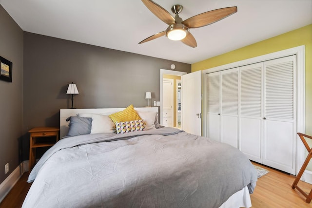 bedroom with ceiling fan, light hardwood / wood-style floors, and a closet