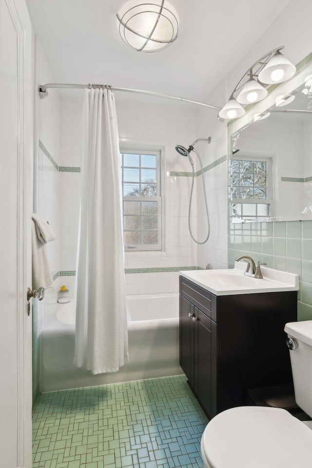 full bathroom featuring shower / tub combo, vanity, plenty of natural light, and tile walls