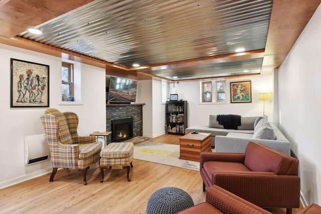 living room with wood ceiling, a fireplace, and light hardwood / wood-style flooring