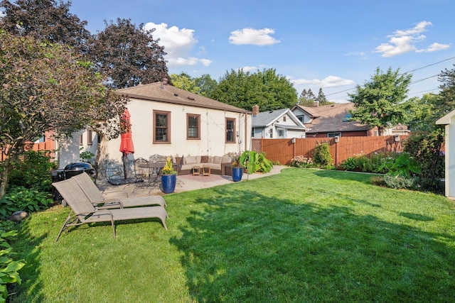 rear view of property with a lawn, outdoor lounge area, and a patio