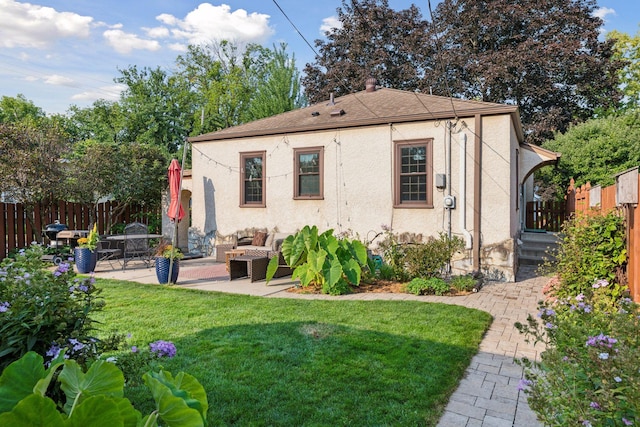 back of house with a lawn and a patio