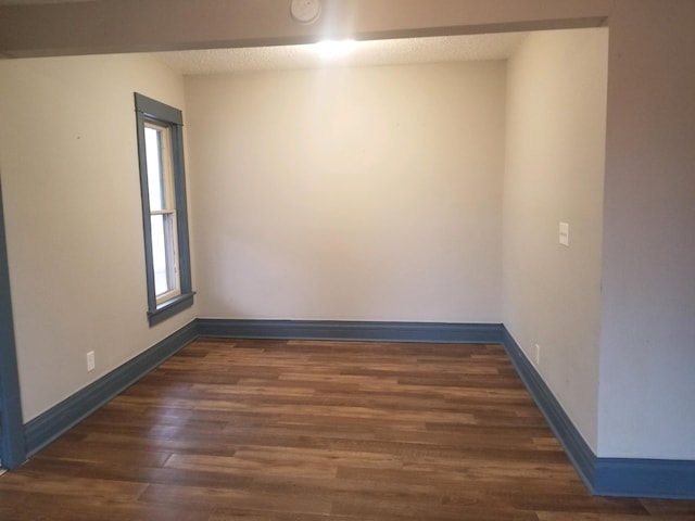 empty room with dark hardwood / wood-style flooring