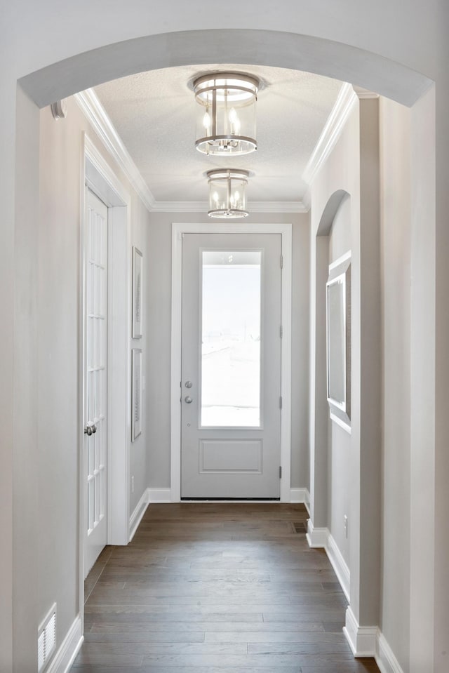 entryway featuring an inviting chandelier, wood-type flooring, and ornamental molding