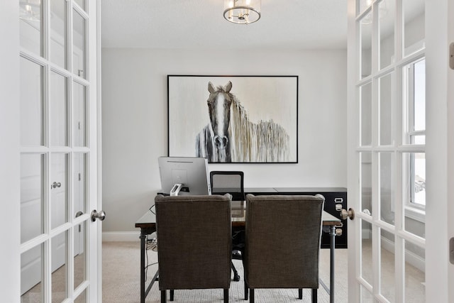 carpeted dining room with french doors