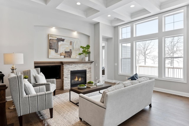 living room featuring coffered ceiling, a fireplace, hardwood / wood-style floors, and beam ceiling