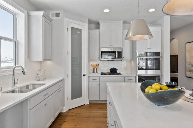 kitchen with white cabinetry, appliances with stainless steel finishes, sink, and light wood-type flooring