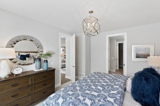 bedroom with a textured ceiling and an inviting chandelier