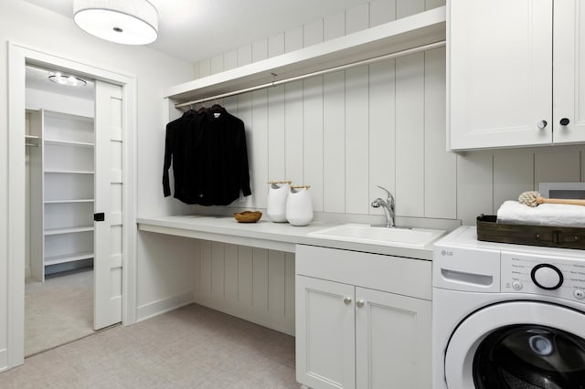 clothes washing area featuring washer / clothes dryer, sink, light colored carpet, and cabinets