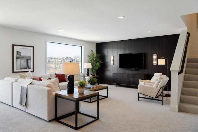 living room featuring wooden walls and light carpet