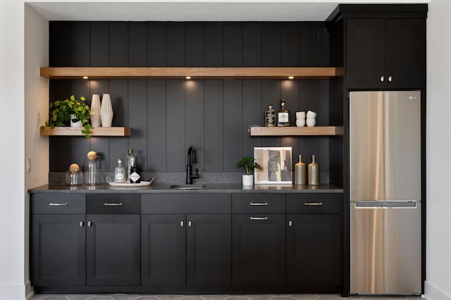 bar featuring stainless steel fridge and sink