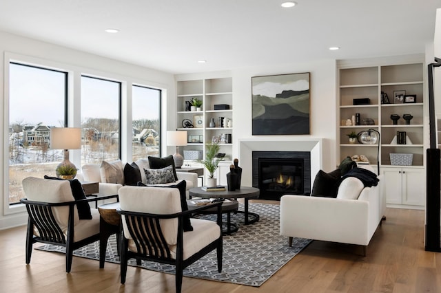 living room with hardwood / wood-style floors, plenty of natural light, and built in shelves