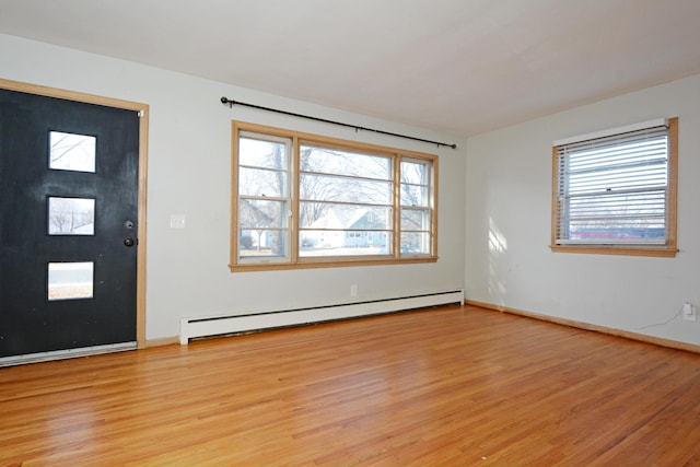 entrance foyer featuring a wealth of natural light, a baseboard radiator, and light wood-type flooring