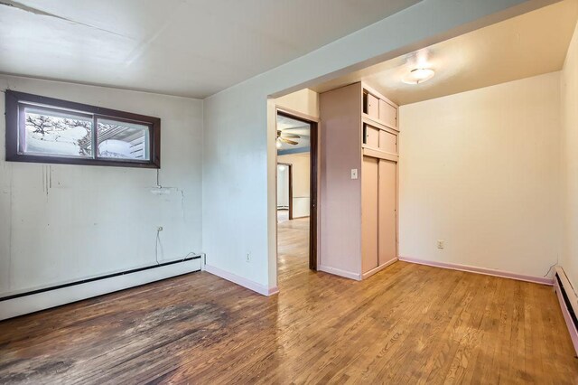 unfurnished room featuring a baseboard radiator, light hardwood / wood-style flooring, and ceiling fan