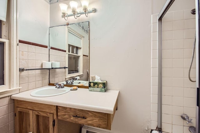 bathroom with tiled shower, vanity, tasteful backsplash, and tile walls