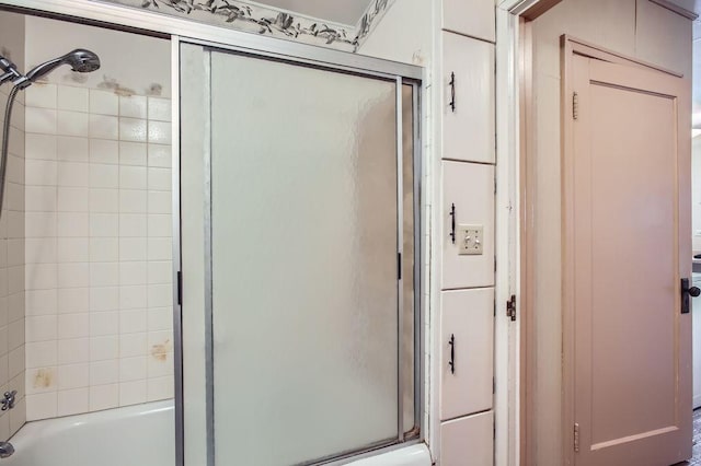 bathroom featuring bath / shower combo with glass door