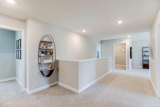 corridor featuring light colored carpet