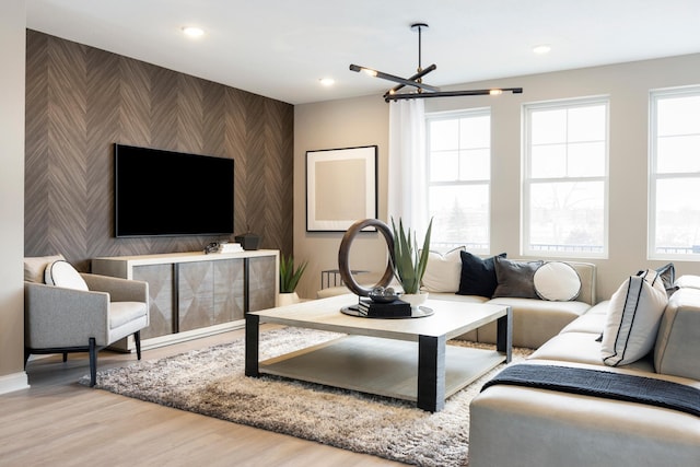 living room with a wealth of natural light, a chandelier, and hardwood / wood-style flooring