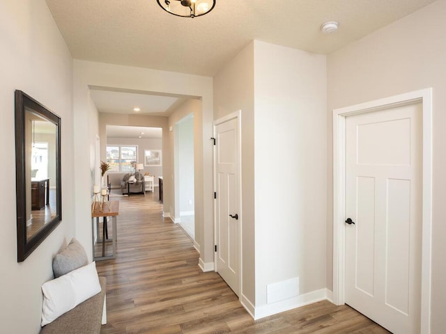 corridor with hardwood / wood-style floors