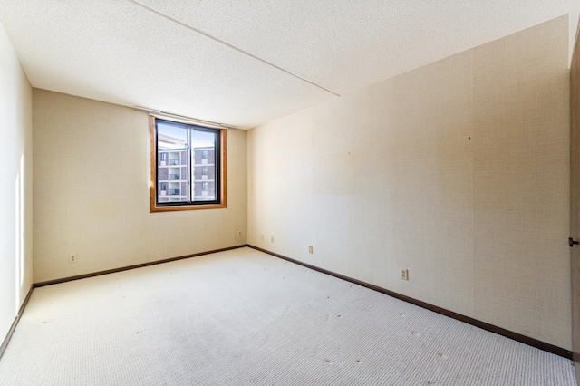 carpeted empty room featuring a textured ceiling