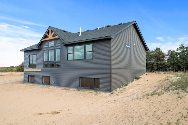 view of property exterior featuring a shingled roof