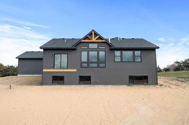 rear view of property with roof with shingles