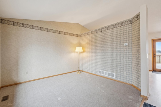 empty room with carpet flooring and vaulted ceiling