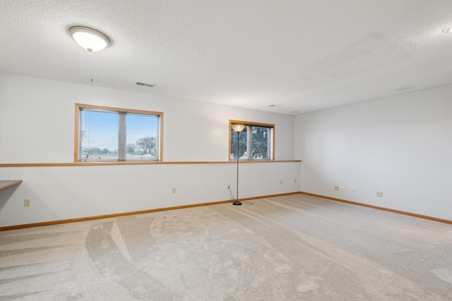 spare room with carpet flooring and a textured ceiling