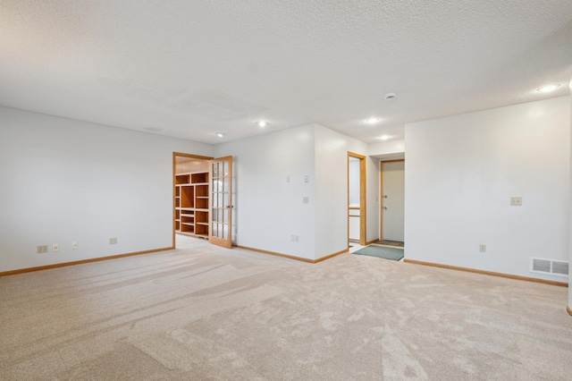 carpeted empty room with a textured ceiling