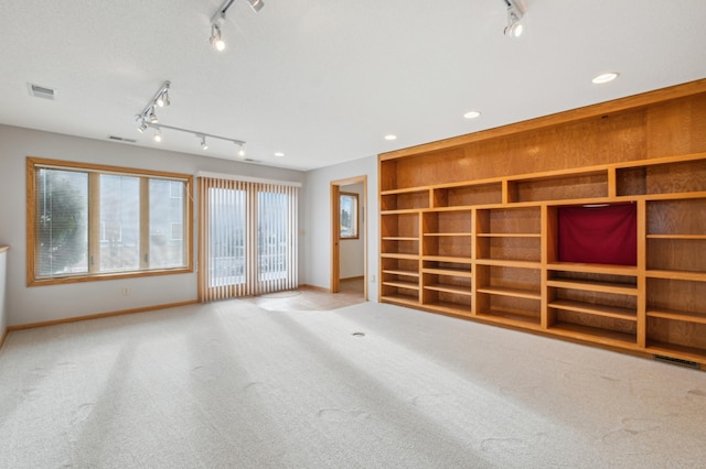 unfurnished living room featuring french doors, light colored carpet, and built in features