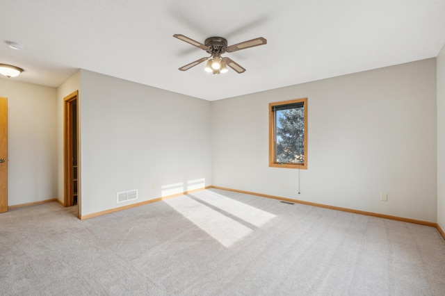 carpeted spare room featuring ceiling fan