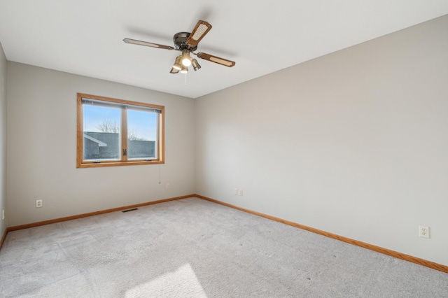 carpeted spare room featuring ceiling fan