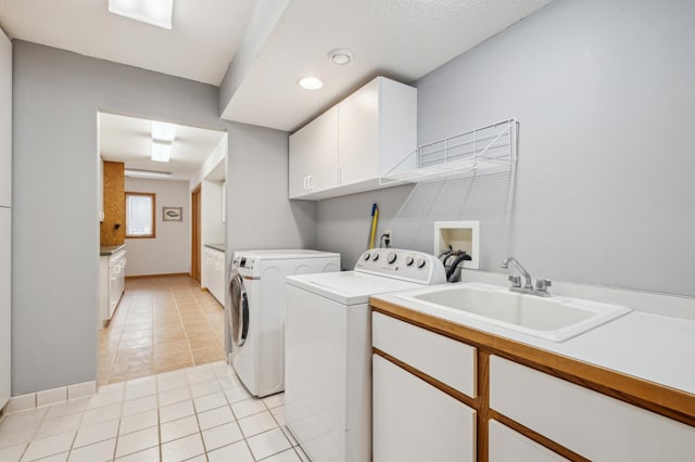 laundry room featuring sink, light tile patterned floors, cabinets, and independent washer and dryer