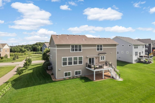 back of property with a lawn and a deck