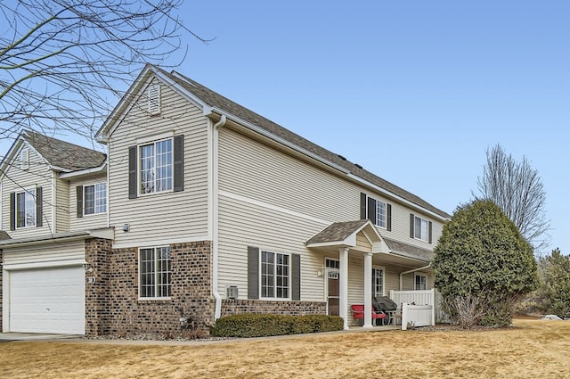 traditional-style house with brick siding, a porch, and an attached garage