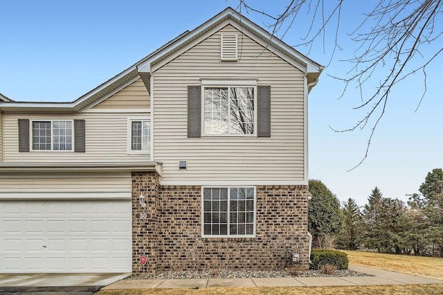 view of property exterior with brick siding and an attached garage