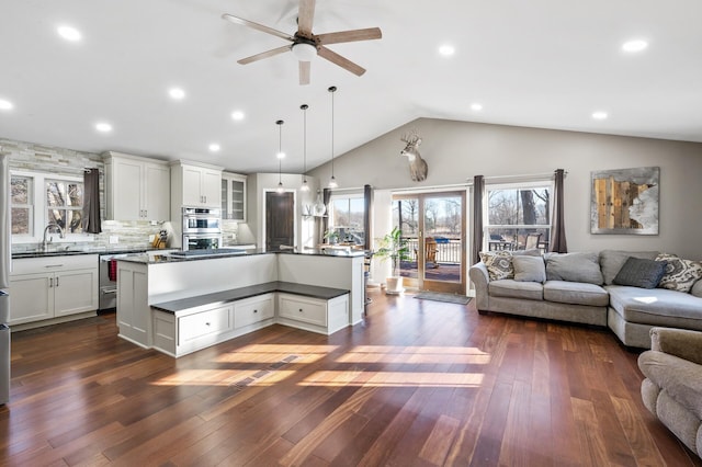 kitchen featuring white cabinets, tasteful backsplash, a kitchen island, and hanging light fixtures