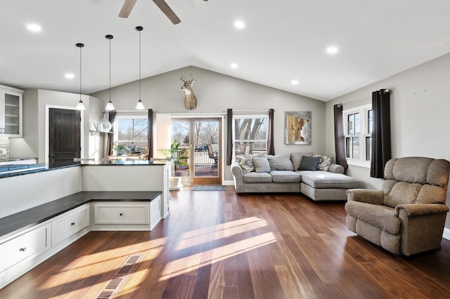 living room featuring vaulted ceiling, ceiling fan, and dark wood-type flooring