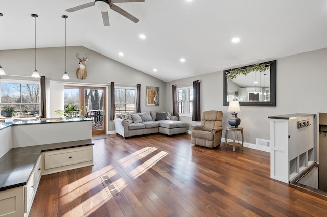 living room featuring dark hardwood / wood-style floors, vaulted ceiling, and ceiling fan