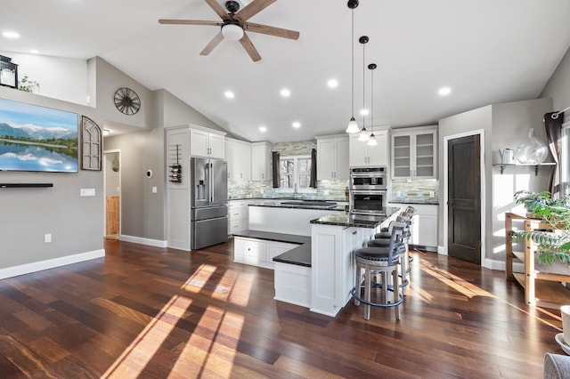 kitchen with white cabinets, a center island, stainless steel appliances, and tasteful backsplash