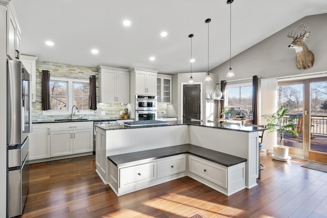 kitchen with white cabinets, a center island, backsplash, and stainless steel appliances