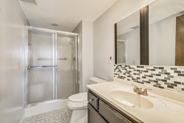 full bathroom with a textured ceiling, a shower stall, tasteful backsplash, toilet, and vanity