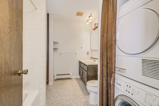 bathroom with estacked washer and dryer, a baseboard heating unit, tile patterned flooring, a bath, and vanity